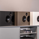 Lyngdorf LCR-2 On-Wall LCR Speaker - three speakers, L-R black brown white, all on cabinet