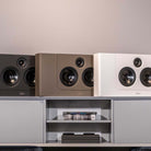 Lyngdorf LCR-2 On-Wall LCR Speaker - three speakers, L-R black brown white, all on cabinet