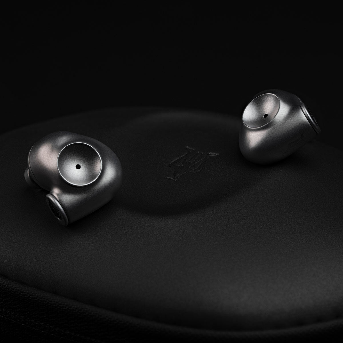Meze Audio ASTRU Single Dynamic Driver In-Ear Monitors - artistic photo of both earbuds on black background