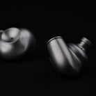 Meze Audio ASTRU Single Dynamic Driver In-Ear Monitors - artistic photo of both earbuds on black background, right earbud in focus showing Meze logo