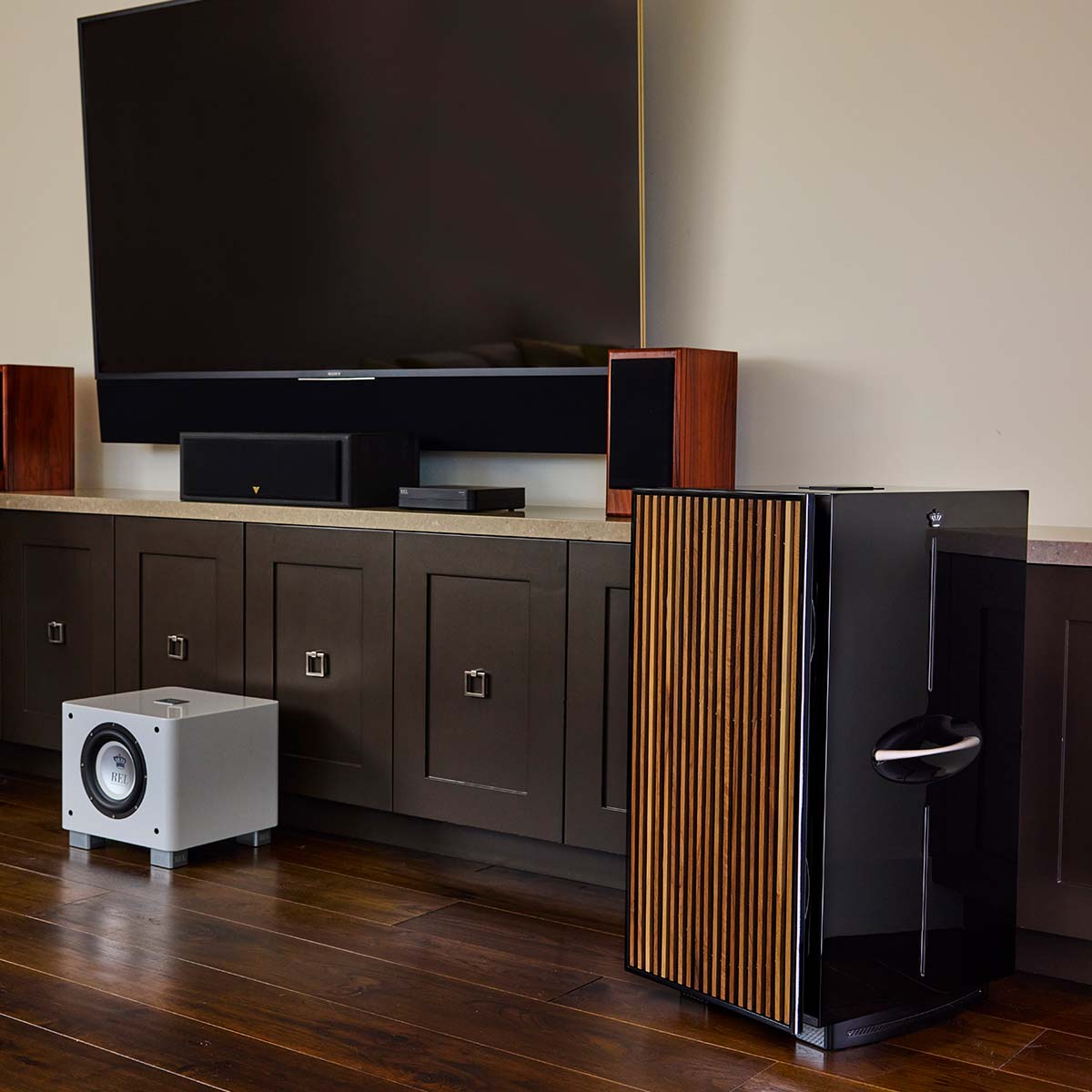 REL Acoustics 212 Black Label Subwoofer with grille lifestyle photo to right of frame