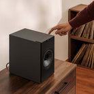 KEF Coda W Powered Speakers - Dark Titanium - lifestyle photo single speaker hand reaching for top buttons