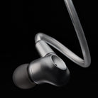 Meze Audio ASTRU Single Dynamic Driver In-Ear Monitors - artistic photo of single earbud connected to cable with eartip on black background