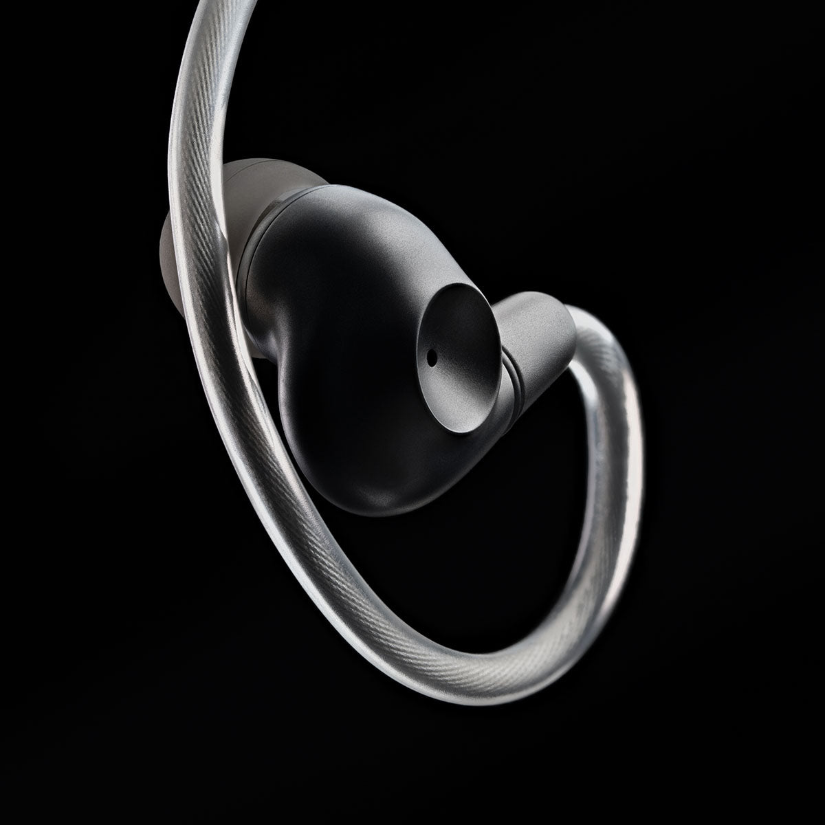 Meze Audio ASTRU Single Dynamic Driver In-Ear Monitors - artistic photo of single earbud connected to cable with eartip on black background