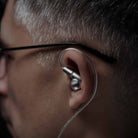 Meze Audio ASTRU Single Dynamic Driver In-Ear Monitors - detail of man with glasses wearing earbud in left ear