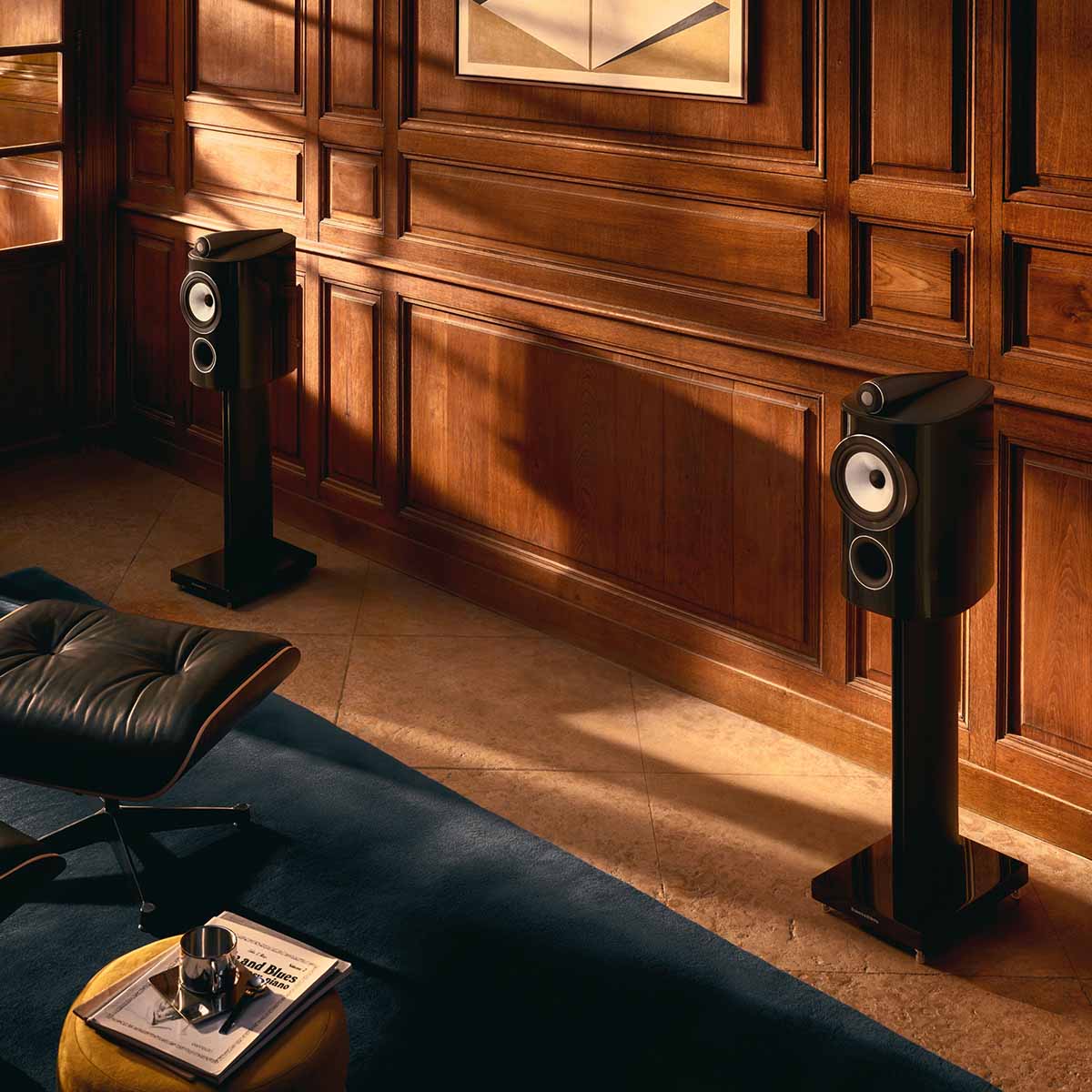 Bowers & Wilkins 805 D5 Bookshelf Loudspeaker - lifestyle photo of pair of Stealth Black speakers on stand without grille facing left