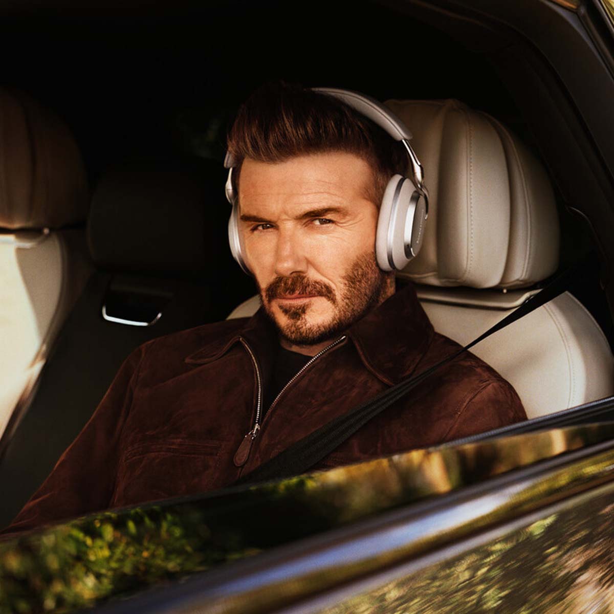 Bowers & Wilkins Px8 S2 Wireless Over-Ear Headphones - Lifestyle photo of David Beckham wearing Stone pair