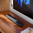 Bluesound Pulse Cinema Mini Multi-Room Streaming Soundbar Black lifestyle photo of unit on cabinet below TV