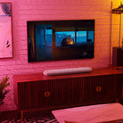 Bluesound Pulse Cinema Mini Multi-Room Streaming Soundbar Tan lifestyle photo of unit on cabinet below TV