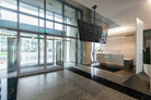 Modern office lobby with glass doors and a reception desk.