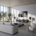 Lyngdorf Cue-100 Speaker lifestyle photo of speakers in living room, pair of black speakers with oak base and no grilles