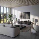 Lyngdorf Cue-100 Speaker lifestyle photo of speakers in living room, pair of speakers with oak base and green grilles