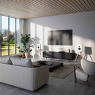Lyngdorf Cue-100 Speaker lifestyle photo of speakers in living room, pair of white speakers with oak base and no grilles