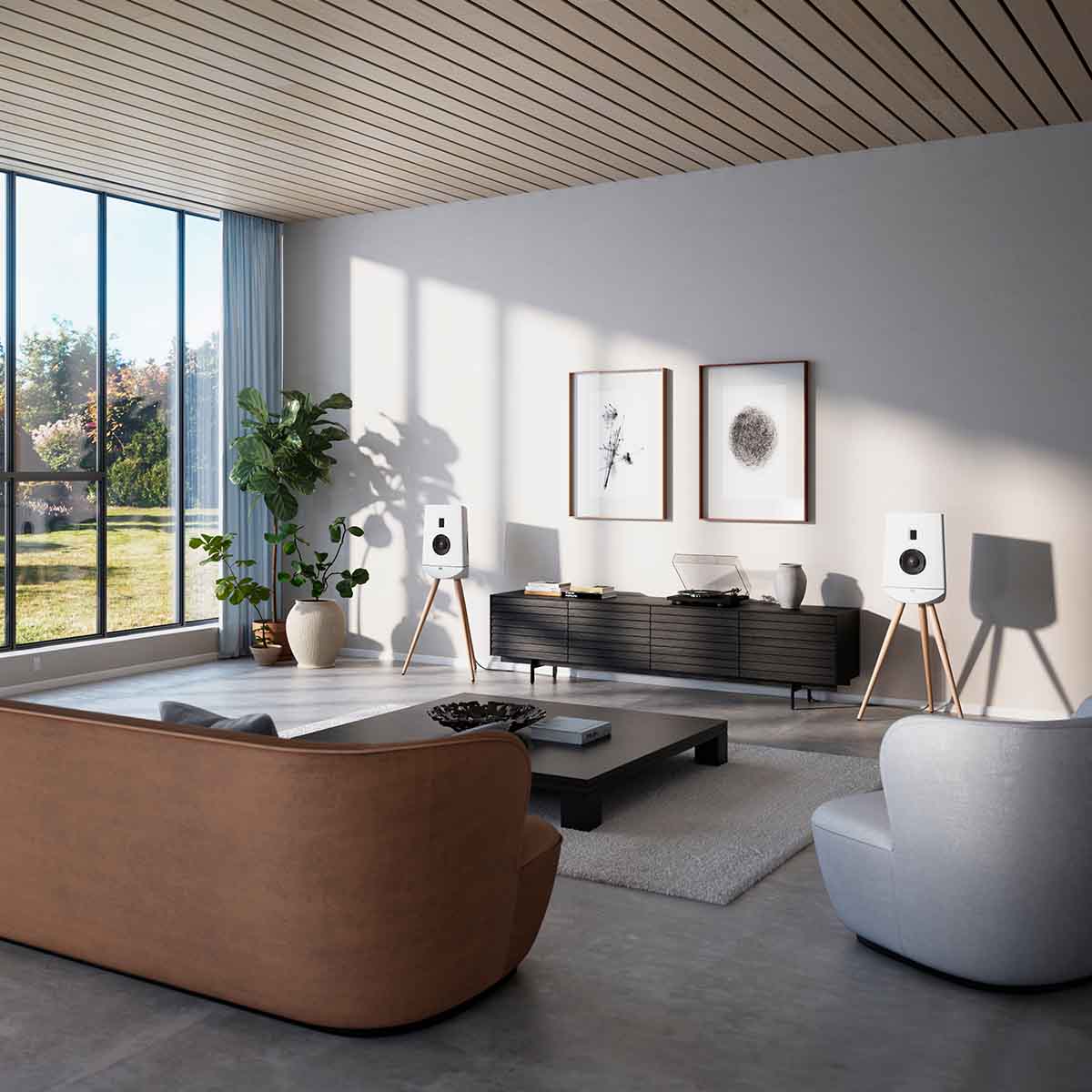 Lyngdorf Cue-100 Speaker lifestyle photo of speakers in living room, pair of white speakers with oak base and no grilles