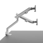 Monitor arm attached to a desk on a white background