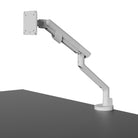 White adjustable monitor stand on a gray surface with a white background