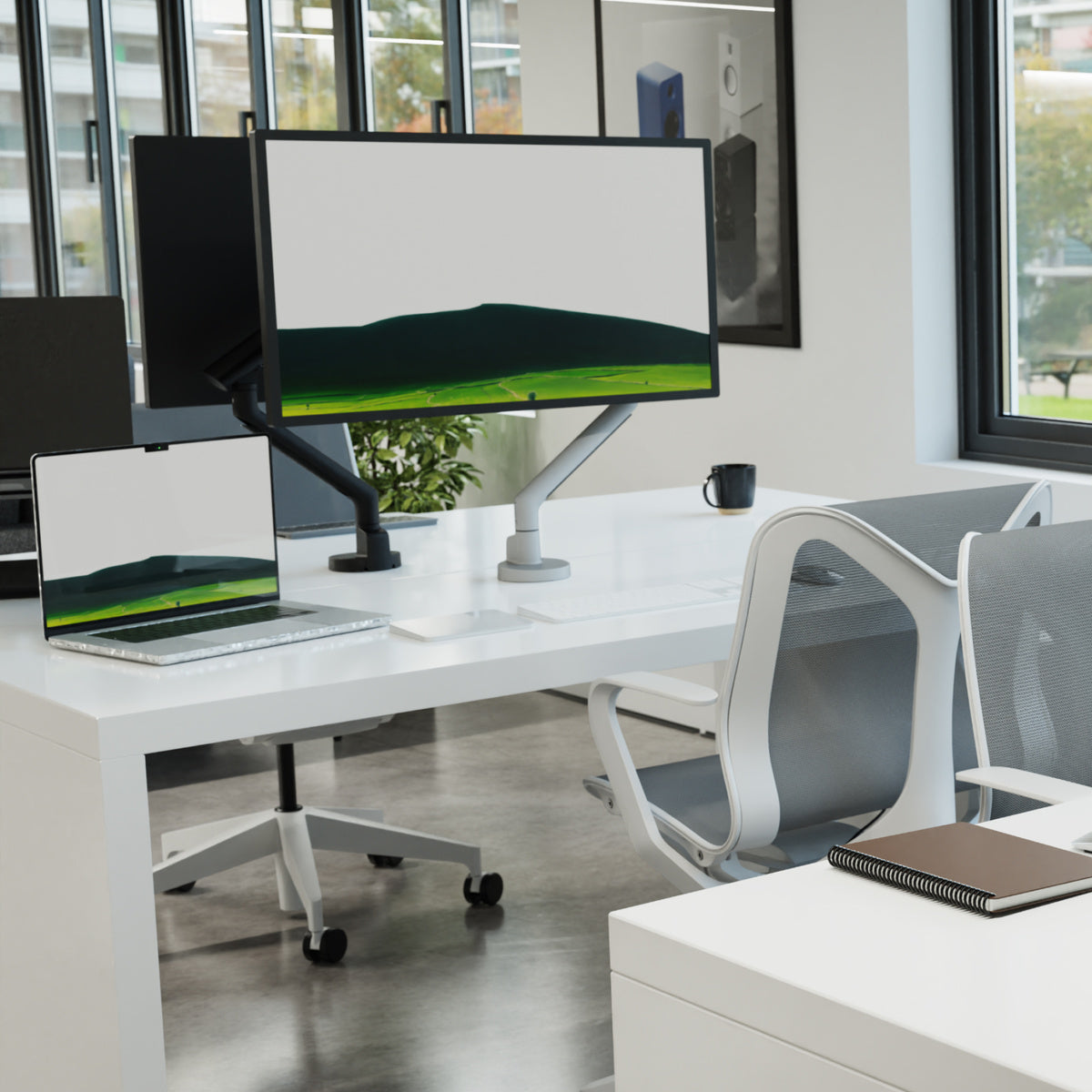 Modern office desk setup with dual monitors, laptop, and chair.