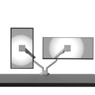Two computer monitors on a desk with a monitor stand on a white background