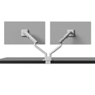 Two computer monitors on adjustable arms attached to a desk with a white background