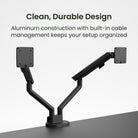 Black dual monitor stand with built-in cable management on a gray surface, text 'Clean, Durable Design' and 'Aluminum construction with built-in cable management keeps your setup organized'.