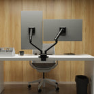 Modern office setup with a desk, chair, and adjustable screen divides against a wooden wall.