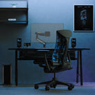 Gaming chair in a dark room with a desk and computer setup.