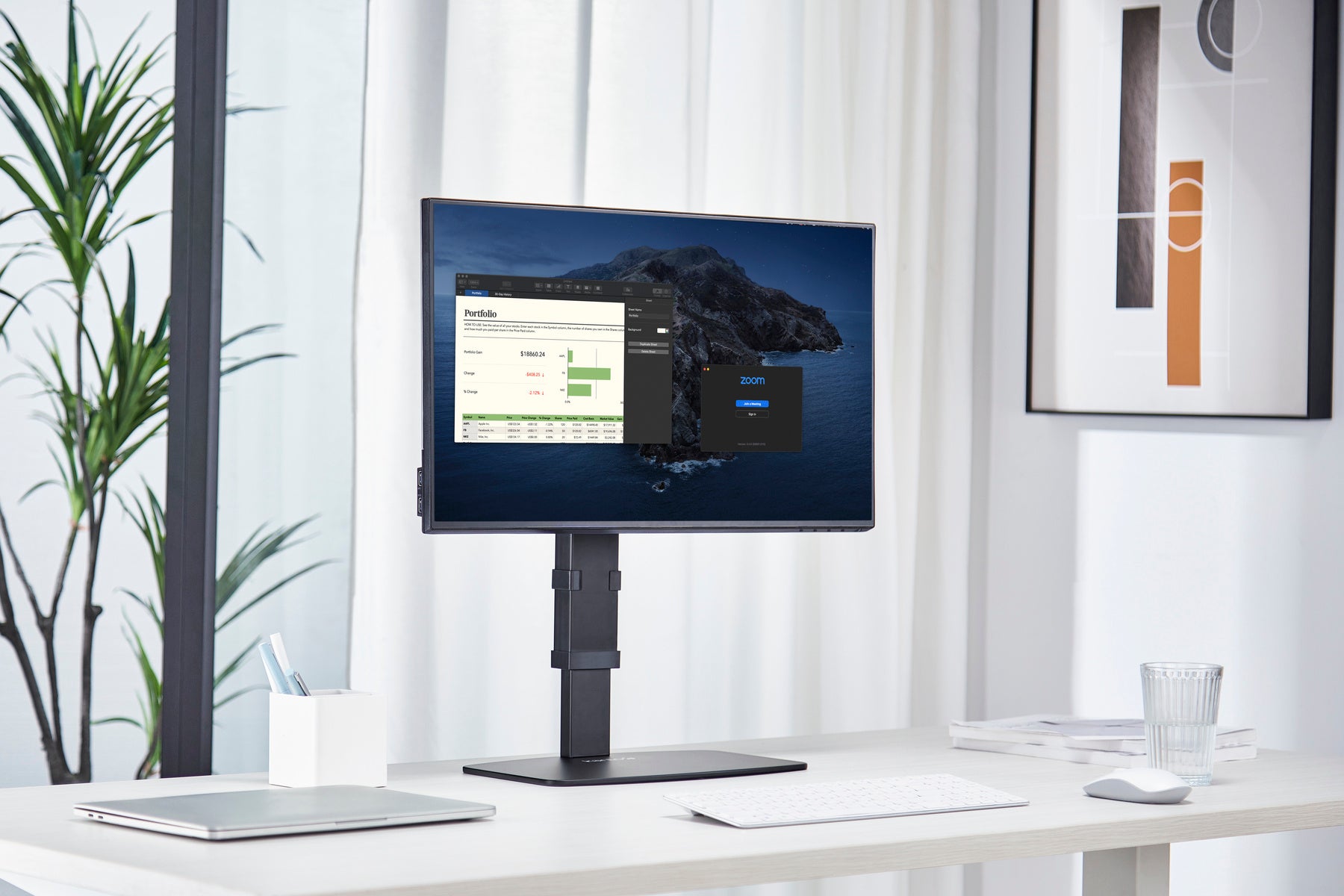 Monitor on a stand in a modern office setting with plants and decor.