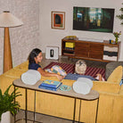 Sonos Beam Ultra Soundbar - lifestyle photo of white soundbar on a cabinet below a TV with couple on a couch in foreground