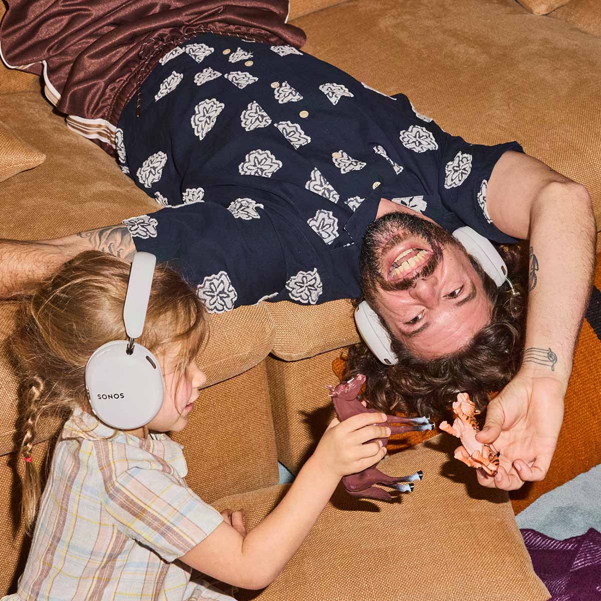 Sonos Ace Ultra Wireless Over-Ear Headphones - lifestyle photo of a man and child both wearing white headphones playing with toys