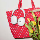 Sonos Ace Ultra Wireless Over-Ear Headphones - lifestyle photo of white headphones hanging from a red tote bag
