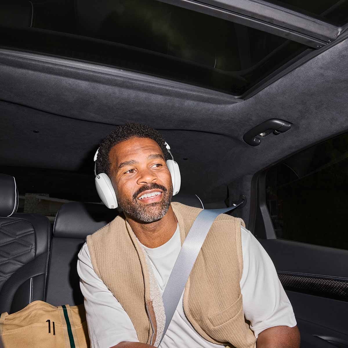 Sonos Ace Ultra Wireless Over-Ear Headphones - lifestyle photo of a man in a car wearing white headphones