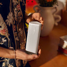 Sonos Roam 2 Portable Waterproof Smart Speaker - white - lifestyle photo person holding speaker