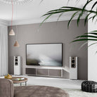 Lyngdorf FR-2 Speaker - lifestyle shot of white speakers with mocca baffles on floor next to wall