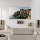 Lyngdorf LCR-2 On-Wall LCR Speaker - lifestyle photo brown speaker mounted below TV with brown Lyngdorf FR-2's to either side