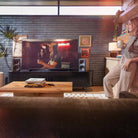 Klipsch The Fives II Dolby Atmos 5.25" Powered Speakers - Pair - lifestyle photo pair of walnut speakers on cabinet with woman to right of room