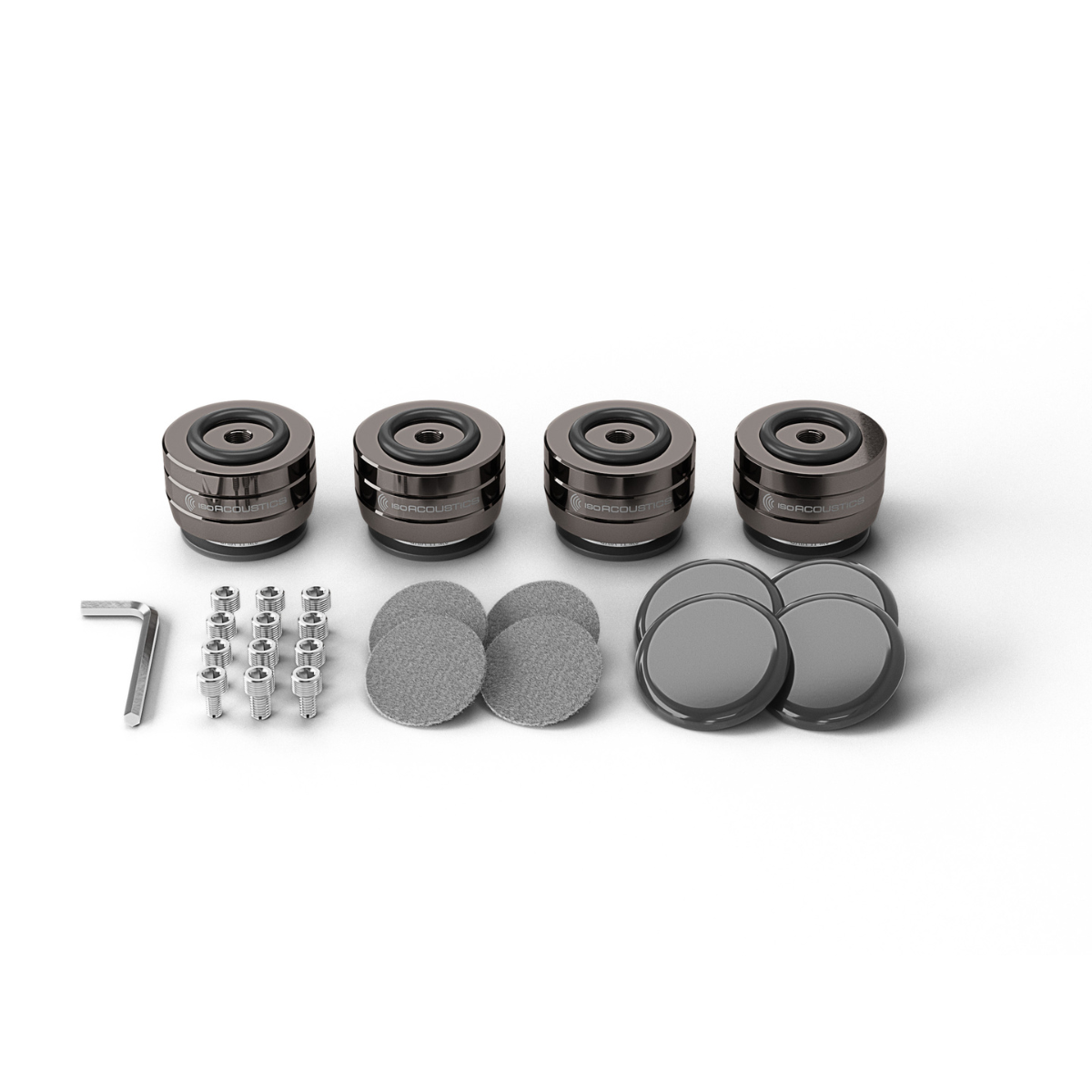 A set of four dark IsoAcoustics Gaia II Neo speaker isolators with silver metal pins, a small L-shaped wrench, and four round gray pads, arranged neatly on a white background.