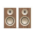 Two matching bookshelf speakers with brown wood-grain fronts, cream-colored drivers, and a small round control knob, shown on a plain white background.