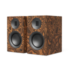 A pair of bookshelf speakers with a distinctive brown and black wavy wood grain pattern, featuring black drivers and a small circular grille on the front.