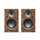 A pair of bookshelf speakers with a distinctive brown and black wavy wood grain pattern, featuring a large woofer and a smaller tweeter on each front panel.