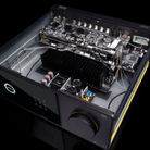 An open-front Arcam Radia AVA15 9-channel Class D Home Theater Receiver photographed at an angle on a black background, showing internal electronics, a large black heatsink, capacitors, and a front control panel with a dial.