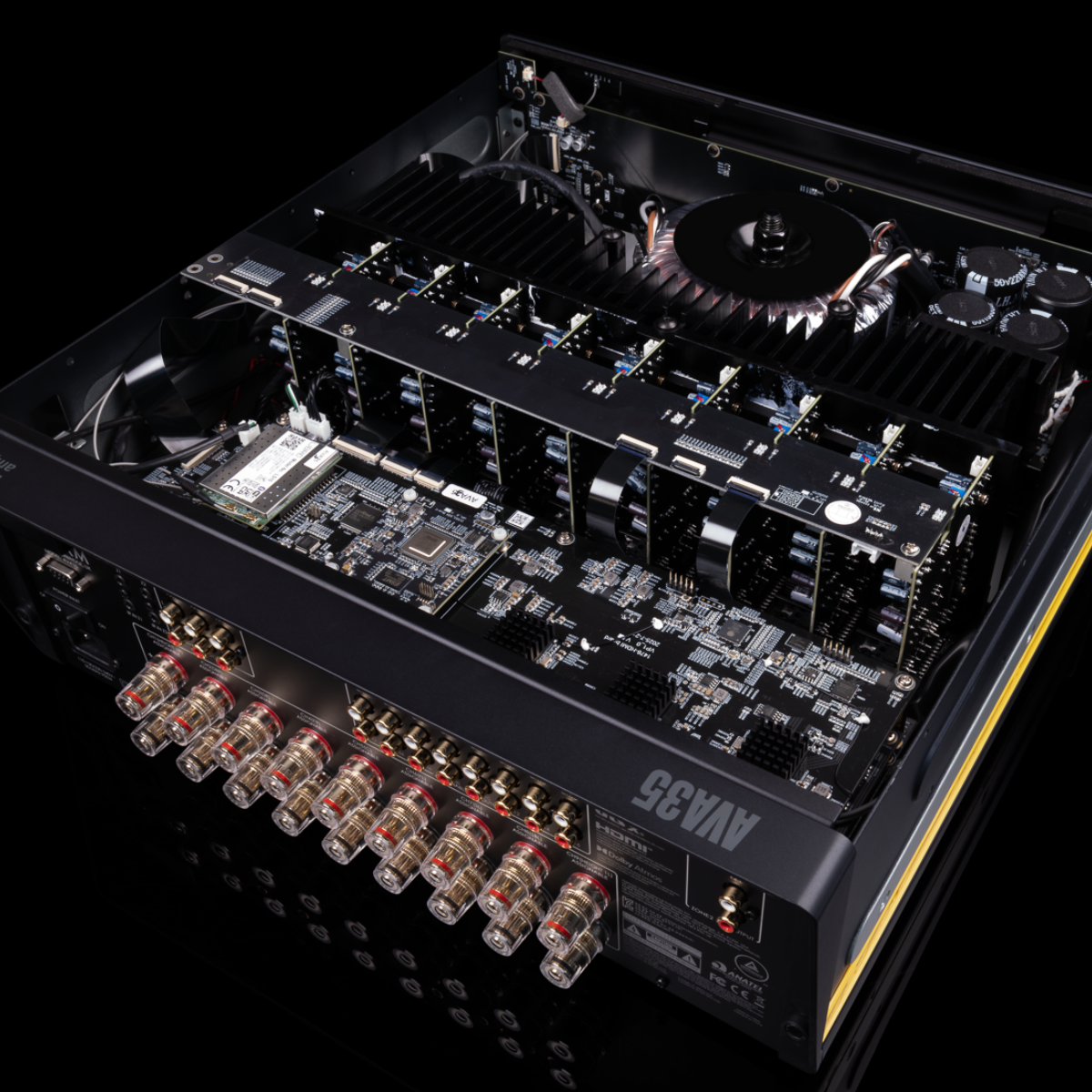 A close-up studio shot of a hArcam Radia AVA35 9-channel Class G Home Theater Receiver with its side panel removed, showcasing the internal circuitry, heat sinks, and multiple front output connectors against a black background.