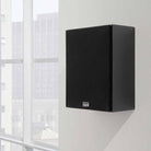 Lyngdorf MH-2 Satellite Speaker lifestyle shot black speaker with black grille mounted on wall