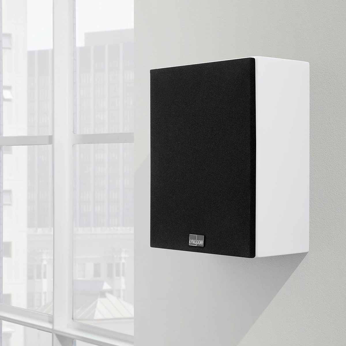 Lyngdorf MH-2 Satellite Speaker lifestyle shot white speaker with black grille mounted on wall