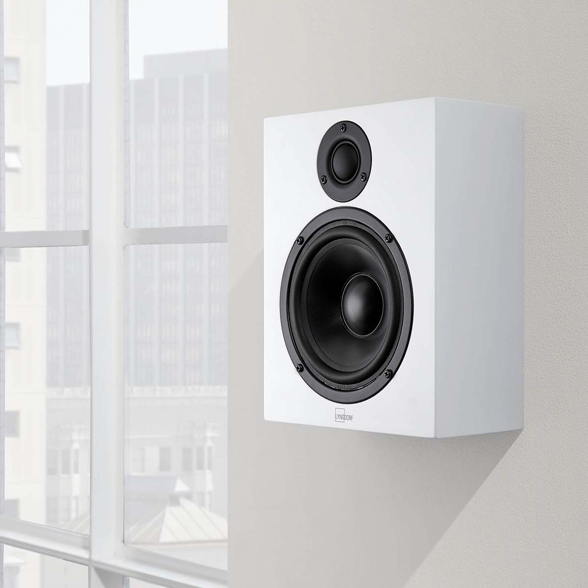 Lyngdorf MH-2 Satellite Speaker lifestyle shot white speaker without grille mounted on wall
