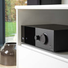 Lyngdorf TDAI-1120 Compact Streaming Amplifier with RoomPerfect lifestyle view of unit in cabinet