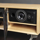Lyngdorf CS-1 Speaker lifestyle shot of speaker in cabinet with door grille open