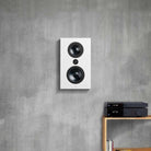 Lyngdorf FR-1 Speaker lifestyle shot front view white unit without grille mounted on gray wall