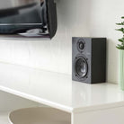 Lyngdorf MH-3 Black Satellite Speaker lifestyle photo unit on cabinet without grille