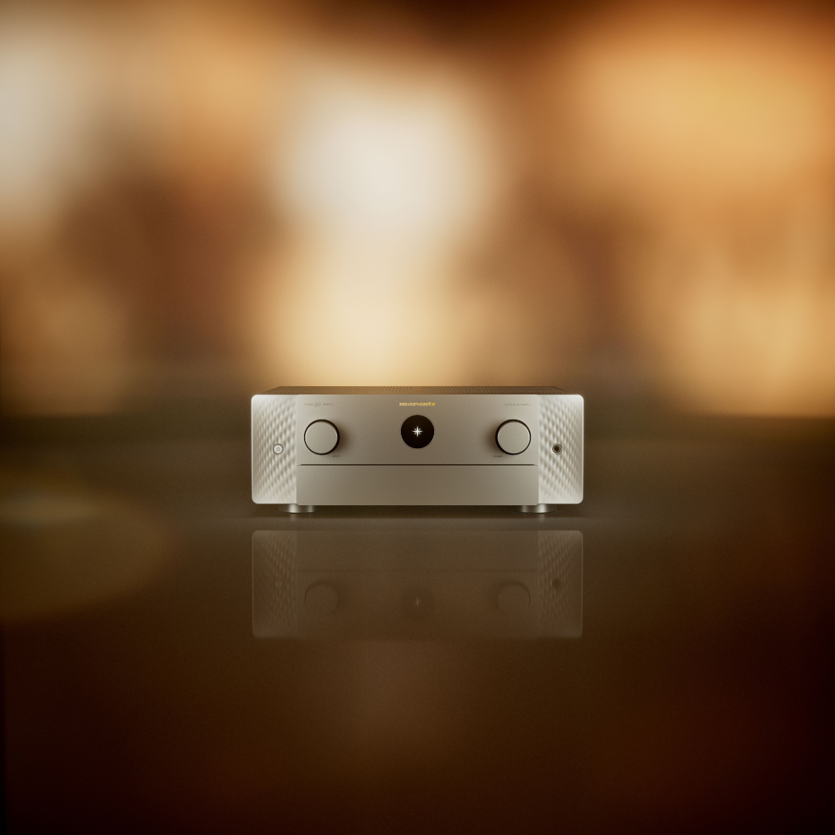 A silver Marantz Cinema 50 Series 2 AV Receiver with two rotary knobs and a central circular detail, displayed on a reflective dark surface against a warm, blurred golden-brown background.