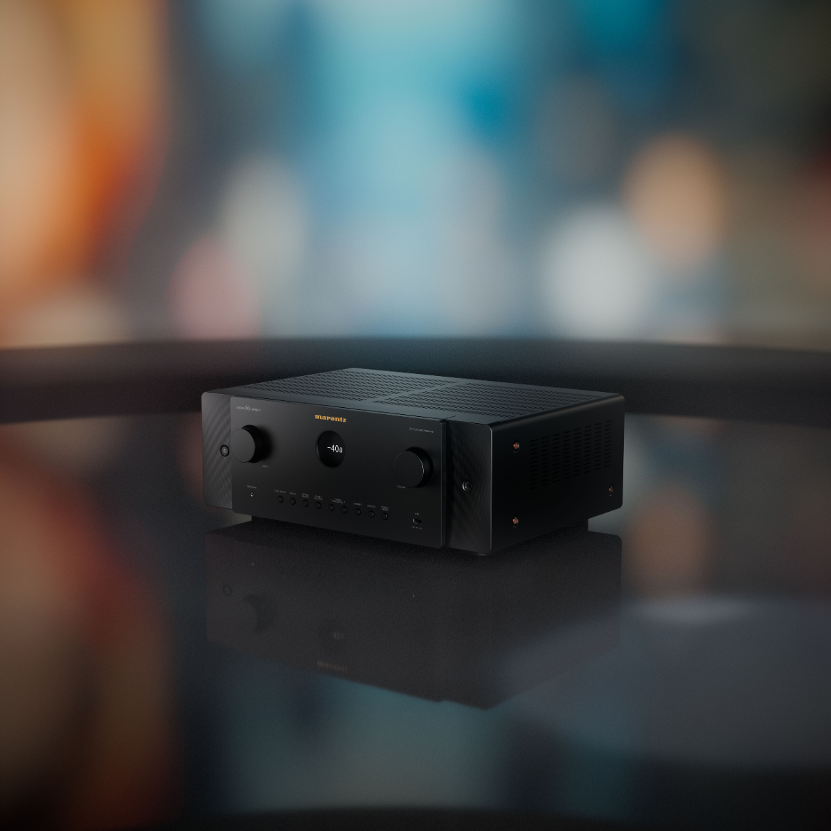 A black Marantz Cinema 60 Series 2 AV Receiver sitting on a glossy dark surface with a blurred indoor background.